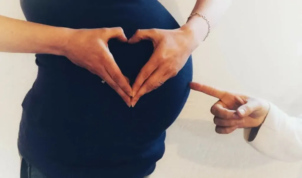 ventre de femme enceinte coeur avec les doigts